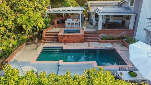 view of pool with an in ground hot tub, area for grilling, an outdoor bar, and a patio