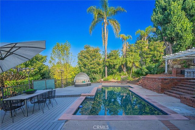 view of swimming pool featuring a pergola and a deck