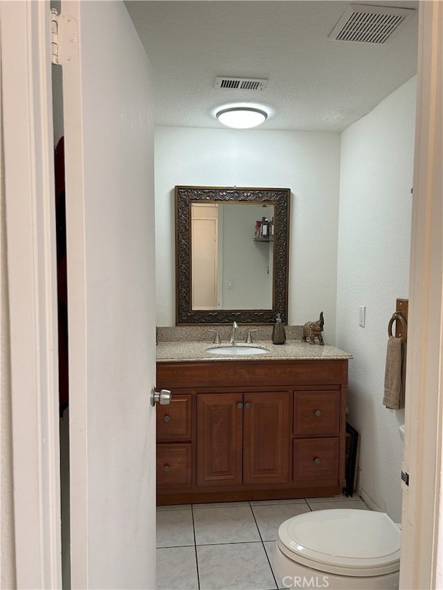 bathroom featuring tile patterned flooring, vanity, and toilet