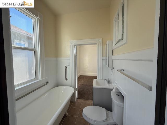 bathroom featuring tile patterned flooring, a bathtub, toilet, and vanity