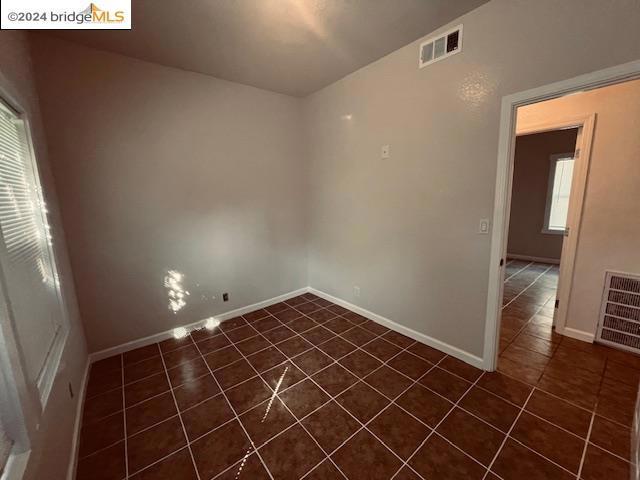 tiled empty room featuring plenty of natural light