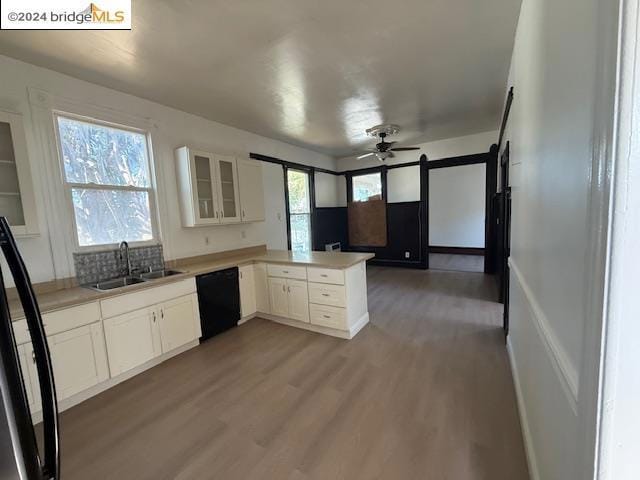 kitchen featuring sink, black dishwasher, kitchen peninsula, refrigerator, and white cabinets