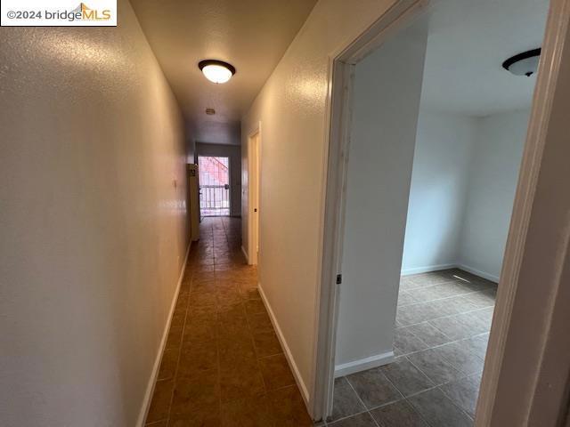 hall with dark tile patterned flooring