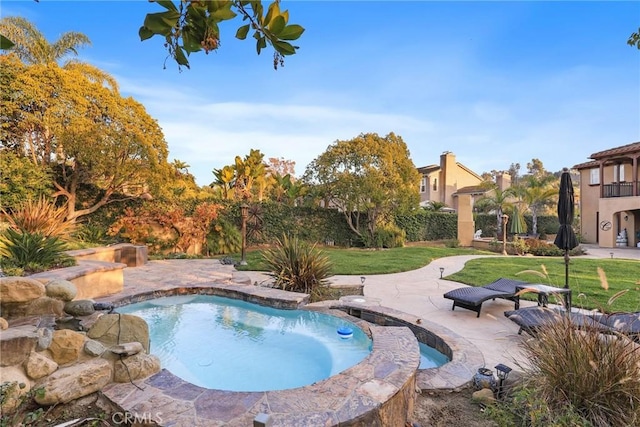 view of pool featuring an in ground hot tub, a yard, and a patio