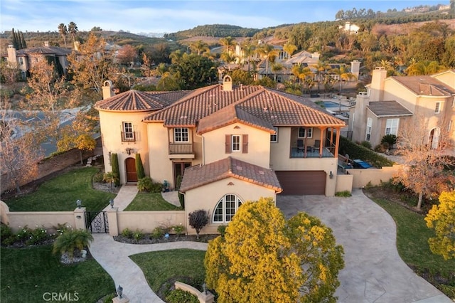 view of front of house featuring a front lawn, a balcony, and a garage