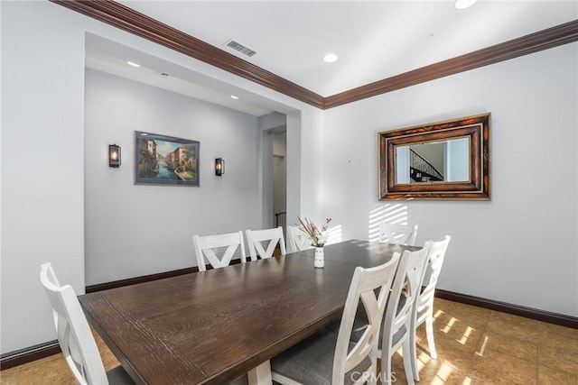 tiled dining space featuring crown molding