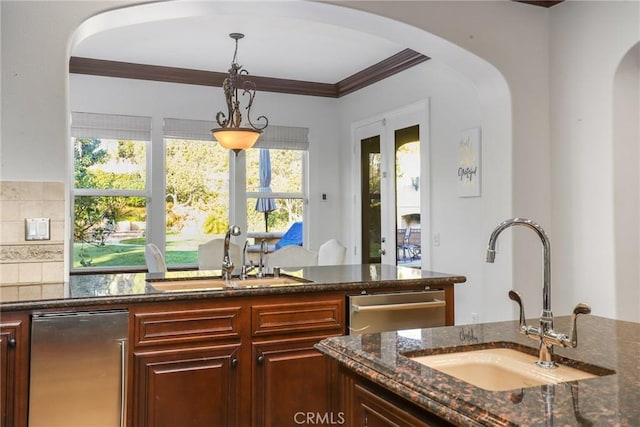 bar featuring hanging light fixtures, sink, stainless steel dishwasher, and dark stone countertops