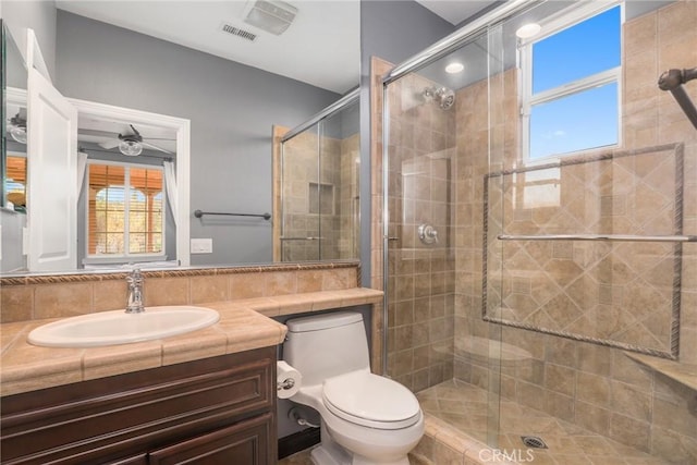 full bath featuring toilet, a shower stall, vanity, and a healthy amount of sunlight