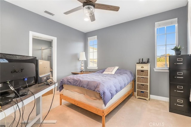 bedroom featuring baseboards, visible vents, a ceiling fan, and light colored carpet