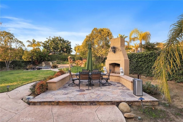 view of patio featuring outdoor dining area and exterior fireplace