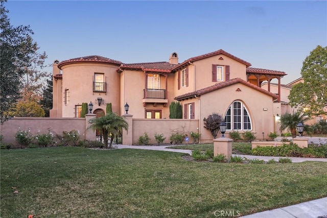 view of front of home featuring a tile roof, fence, a chimney, and stucco siding