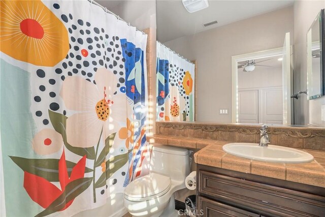 bathroom featuring toilet, vanity, visible vents, and a shower with shower curtain