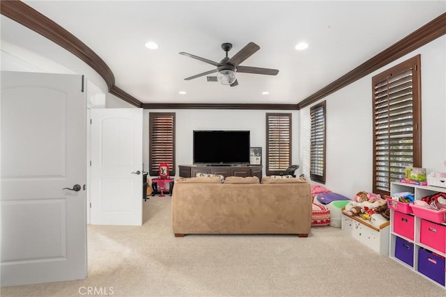 living room featuring ceiling fan, ornamental molding, and light colored carpet