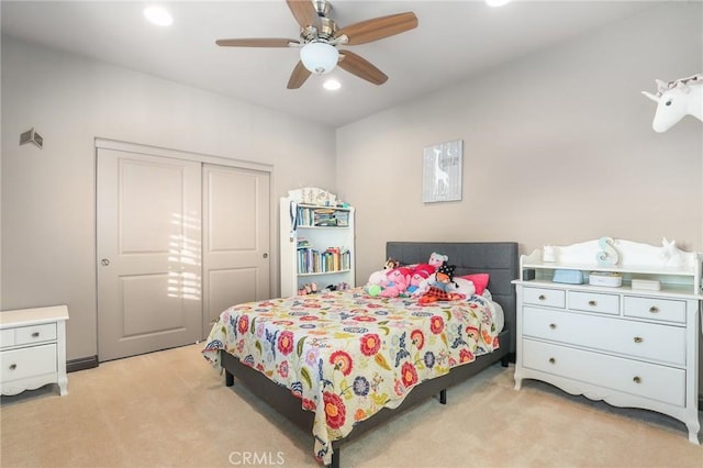 carpeted bedroom featuring ceiling fan and a closet