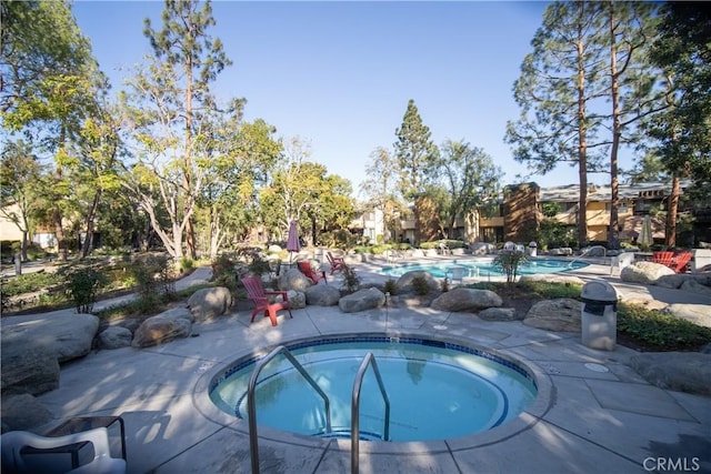 view of pool with a hot tub