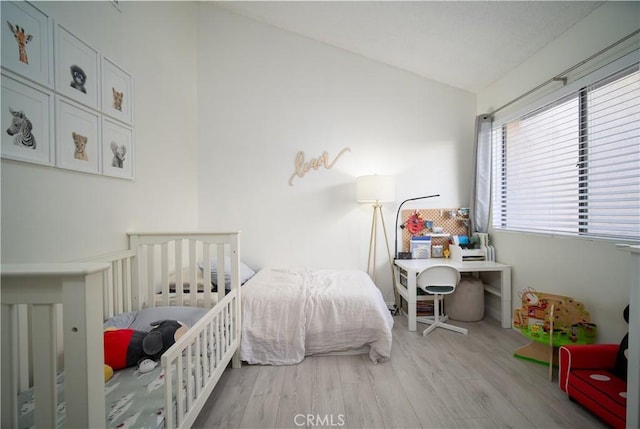 bedroom with light hardwood / wood-style flooring and vaulted ceiling