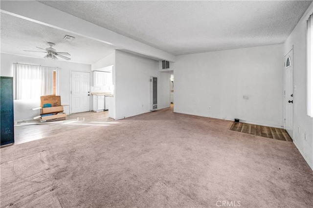 unfurnished living room with ceiling fan, carpet, and a textured ceiling