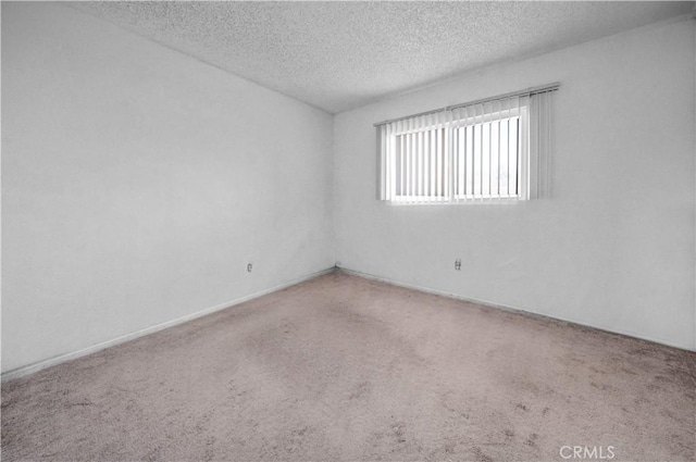 empty room with carpet and a textured ceiling