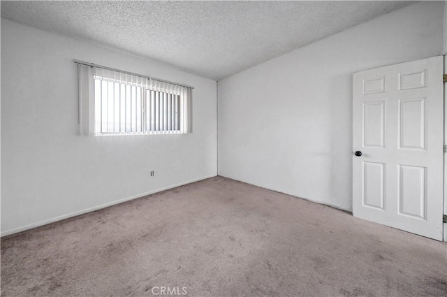 carpeted empty room with a textured ceiling