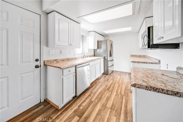 kitchen featuring light wood-type flooring, white cabinetry, sink, and appliances with stainless steel finishes