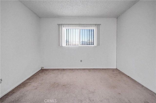 carpeted spare room with a textured ceiling