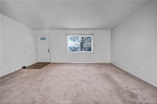 carpeted empty room featuring a textured ceiling