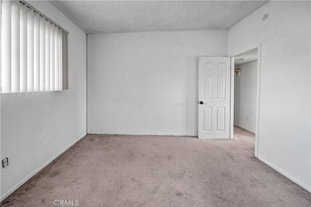 unfurnished room with a textured ceiling and light colored carpet