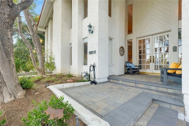 view of exterior entry featuring french doors and a patio