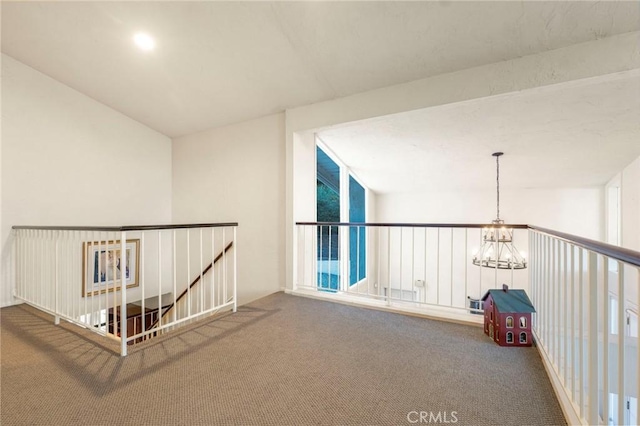 corridor with carpet floors and a notable chandelier