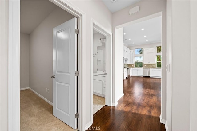 hallway with hardwood / wood-style floors and sink