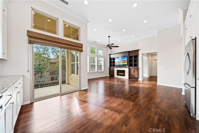 unfurnished living room featuring dark hardwood / wood-style flooring and ceiling fan