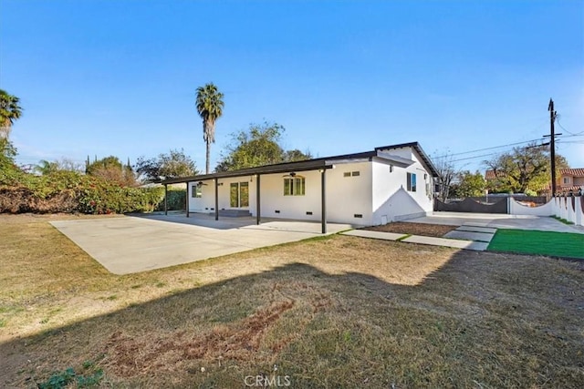 back of property with a patio area and a yard