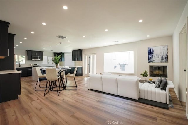 living room with sink and light hardwood / wood-style flooring