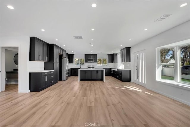 kitchen featuring stainless steel appliances, light hardwood / wood-style floors, and a kitchen island