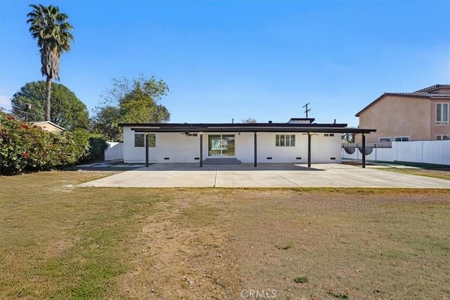 rear view of property featuring a patio area and a lawn