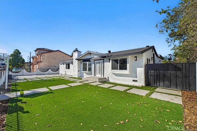 rear view of house featuring a yard