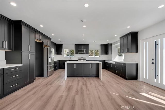 kitchen featuring appliances with stainless steel finishes, light hardwood / wood-style flooring, and a kitchen island