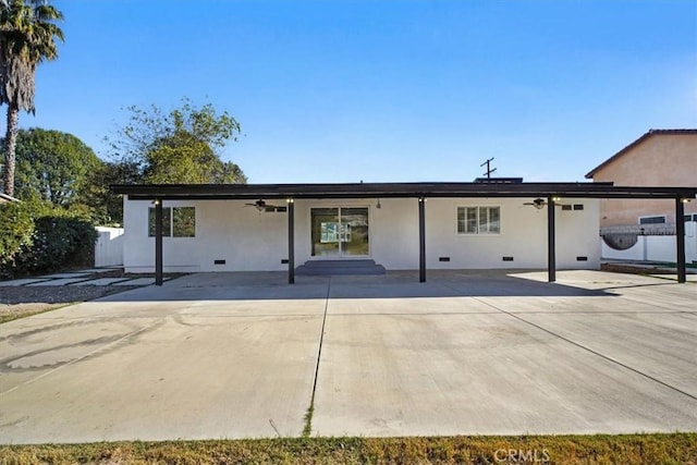 back of property featuring ceiling fan and a patio