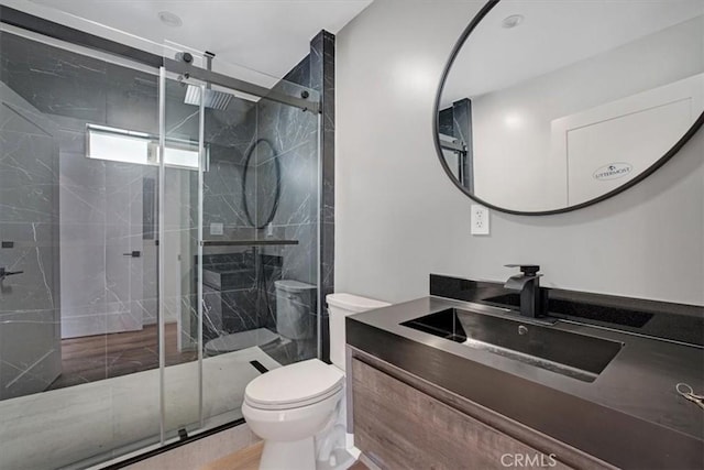 bathroom featuring toilet, an enclosed shower, and vanity