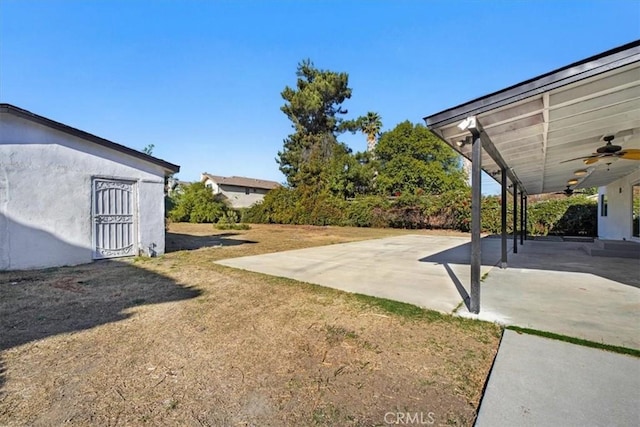 view of yard with ceiling fan and a patio