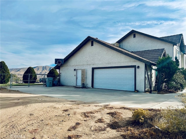 view of property exterior featuring a garage and a mountain view