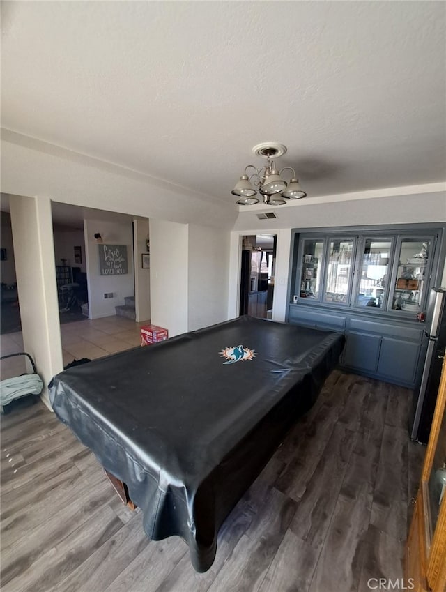 recreation room with an inviting chandelier, hardwood / wood-style floors, and billiards