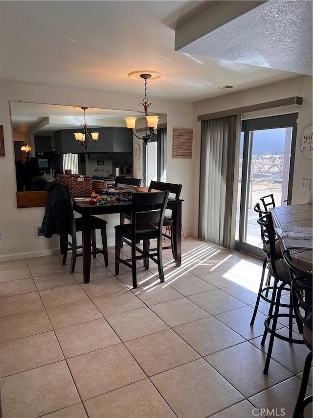 dining space with light tile patterned flooring and a chandelier