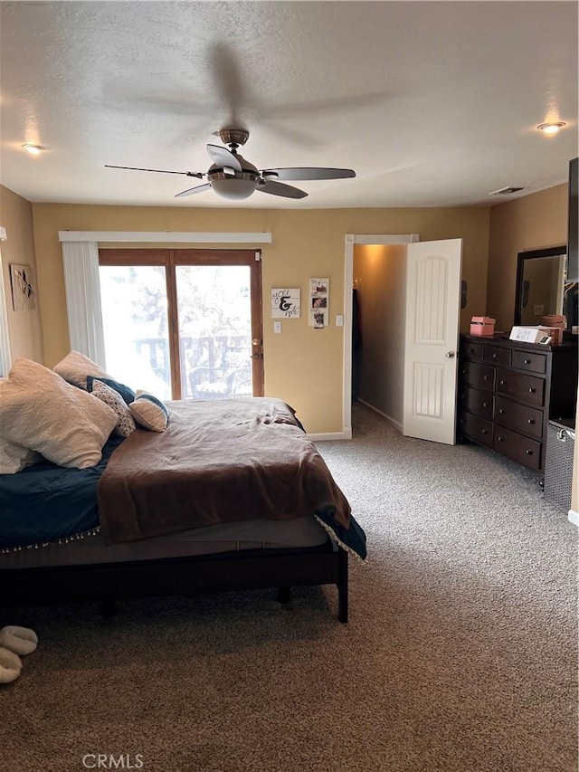 carpeted bedroom with a textured ceiling and ceiling fan