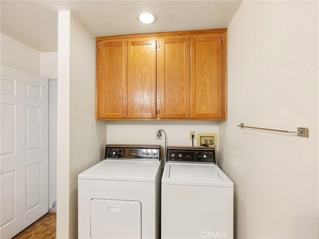 laundry room with light hardwood / wood-style floors, cabinets, and independent washer and dryer