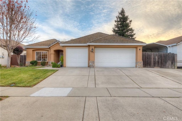 view of front of home with a carport, a garage, and a yard