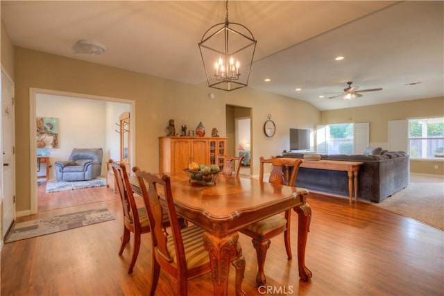 dining room featuring ceiling fan with notable chandelier and light hardwood / wood-style flooring