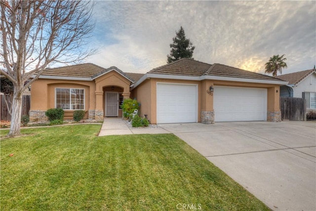 ranch-style house featuring a lawn and a garage