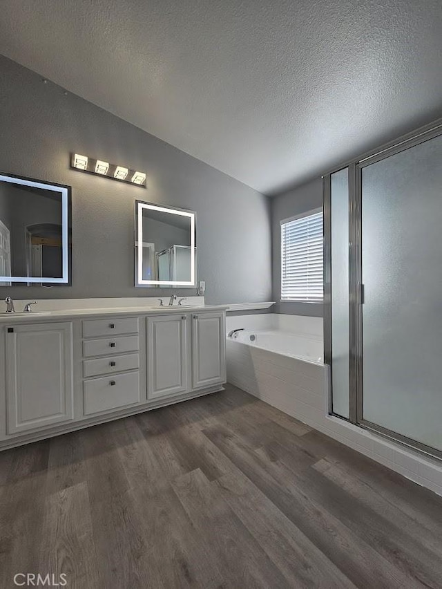 bathroom featuring vanity, wood-type flooring, a textured ceiling, and independent shower and bath