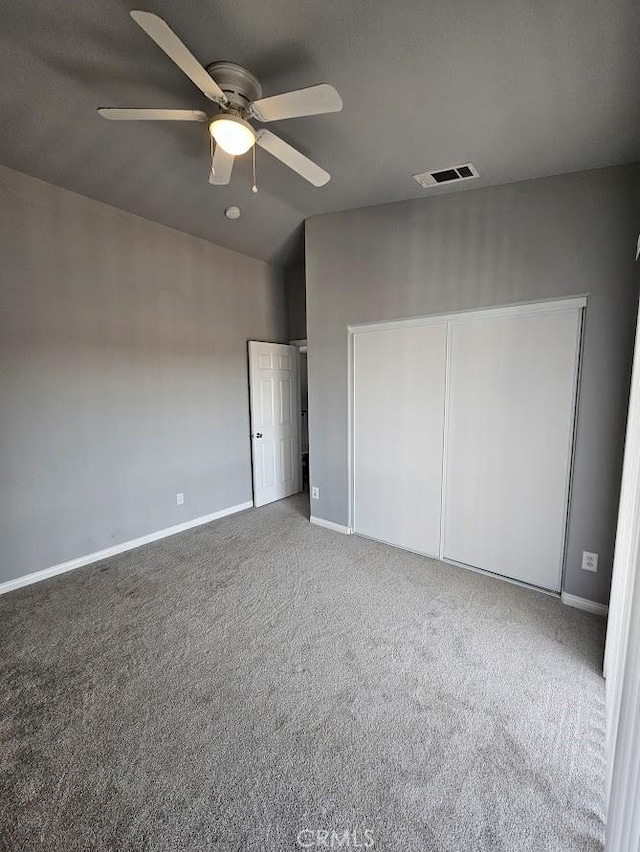 unfurnished bedroom with carpet flooring, a closet, and ceiling fan